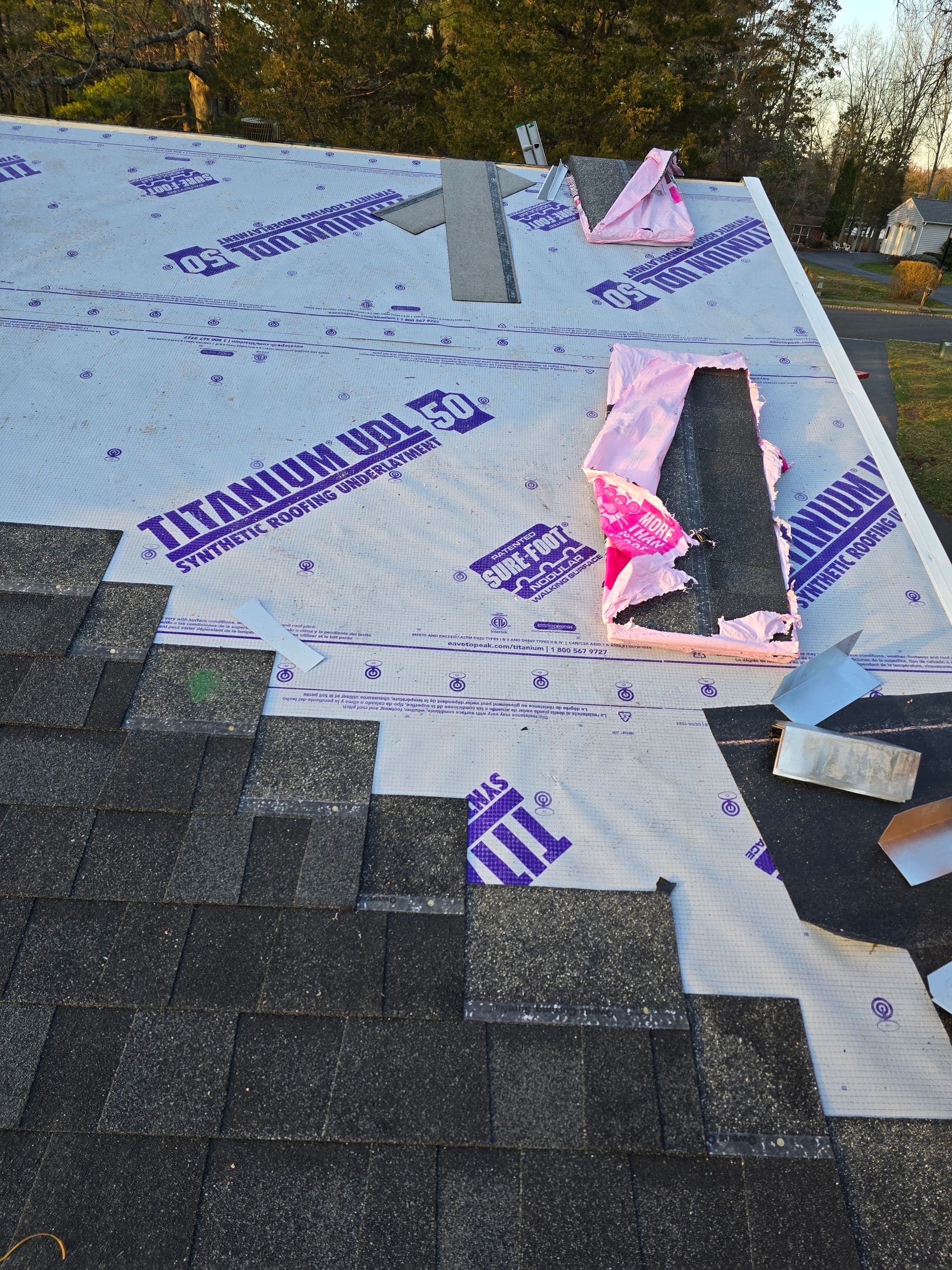 Roofing work in progress with tarp on the roof